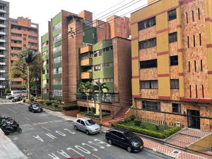 una calle de la ciudad con coches estacionados frente a los edificios en Quiet apartment in Laureles, en Medellín