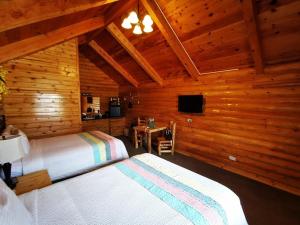 Bryce Canyon Log Cabins في تروبيك: غرفة نوم بسريرين في كابينة خشبية