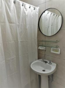 uma casa de banho branca com um lavatório e um espelho em Beños em Buenos Aires