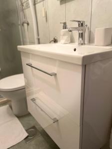 a white bathroom with a sink and a toilet at Jacuzzi apartman Marin in Bol +28 photos