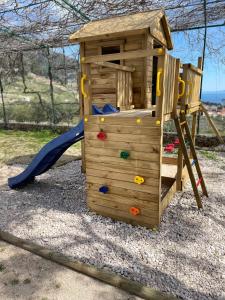 a wooden playground with a slide and a playset at Vacation House Marin with Jacuzzi - Bol, Brač in Bol