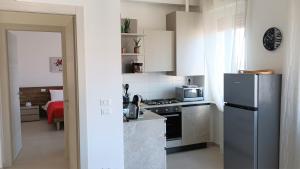 Civico40 Luminoso appartamento con balconi e garage privato في فيرونا: مطبخ صغير مع ثلاجة وموقد