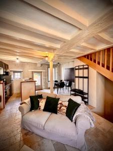 ein Wohnzimmer mit einem weißen Sofa und einem Tisch in der Unterkunft Le Lavoir aux Roses by Gîtes Sud Touraine in Chédigny