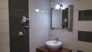 a bathroom with a sink and a mirror at Agia Kiriaki Bungalows in Alikanas