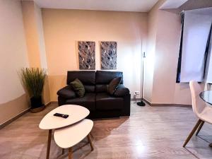 ein Wohnzimmer mit einer Couch und einem Tisch in der Unterkunft AP TURIST VELÁZQUEZ in Alicante