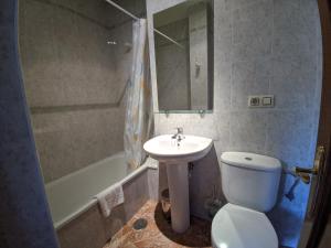 a bathroom with a white toilet and a sink at Apartamentos Bricia in Posada de Llanes +35 photos