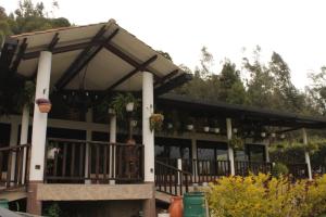 - un bâtiment avec une terrasse couverte agrémentée de plantes dans l'établissement Villa Germana, à Paipa