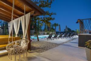 eine Terrasse mit Stühlen und einem Pool in der Unterkunft Piccola Villa Adriatic, with heated swimming pool, Opatija in Ičići