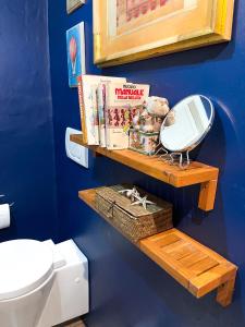 een badkamer met een toilet en een plank met een spiegel bij Casa Elena Pietrasanta in Pietrasanta