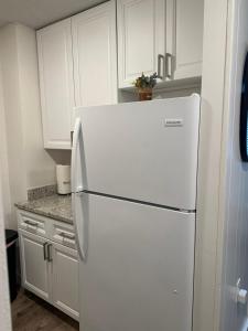 een witte koelkast in een keuken met witte kasten bij Beautiful renovated Studio Apartment in Gadsden AL in Gadsden