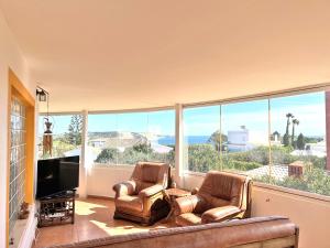 sala de estar con 2 sillas y ventana grande en Private Villa Rego with Oceanview and Pool en Luz