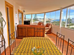 a living room with a table and some windows at Private Villa Rego with Oceanview and Pool in Luz