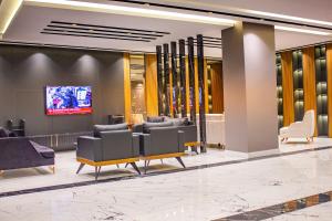 a lobby with couches and a tv in a building at Sumela Park Hotel in Trabzon