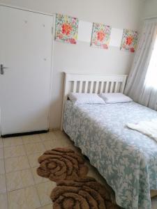 1 dormitorio con cama y alfombra en el suelo en Country Block, en Gaborone