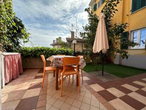 een tafel en stoelen en een parasol op een patio bij Appartamenti a Cà Mia in La Spezia