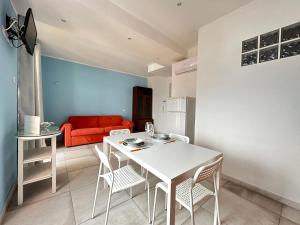 a living room with a white table and chairs and a red couch at Appartamenti a Cà Mia in La Spezia