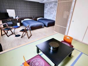 Apprising hotels GranJam Tsugaike - Vacation STAY 77381v في Chikuni: غرفة معيشة مع سرير وطاولة وكراسي