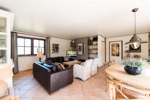 a living room with a couch and a table at Villa met grote tuin in de duinen nabij het strand in Buren