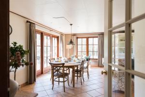 una sala da pranzo con tavolo e sedie di Villa met grote tuin in de duinen nabij het strand a Buren