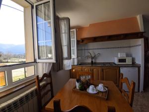 a kitchen with a wooden table and a kitchen with a window at Apartamentos Bricia in Posada de Llanes