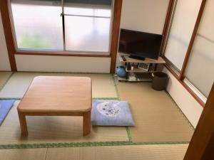 a living room with a table and a television at D-pdal Inn 1F - Vacation STAY 14134 in Tokyo