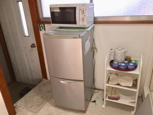 a microwave on top of a refrigerator in a kitchen at D-pdal Inn 1F - Vacation STAY 14134 in Tokyo