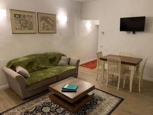 ein Wohnzimmer mit einem Sofa und einem Tisch in der Unterkunft Bilocale nel cuore di Firenze in Florenz