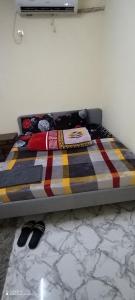 a bed with a colorful blanket on it in a room at Adex Cool Apartment in Abu Dhabi