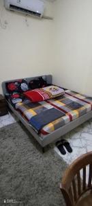 a bed sitting in a room with at Adex Cool Apartment in Abu Dhabi