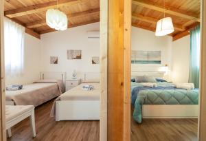 a bedroom with two beds in a room with wooden ceilings at Case Vacanze la fenice- Casa Mediterranea in Cava dʼAliga +27 photos