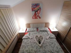 a bedroom with a bed with a heart on it at Apartman Dionis SM in Sremska Mitrovica