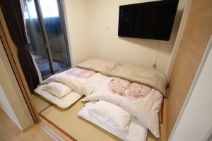 two beds in a room with a flat screen tv at Airport Kikuyo Forest - Vacation STAY 14128 in Kikuyo