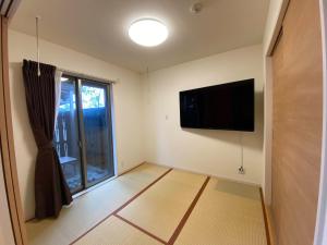 Il comprend un salon doté d'une télévision à écran plat et d'une fenêtre. dans l'établissement Airport Kikuyo Forest - Vacation STAY 14128, à Kikuyo