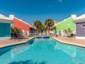 Una piscina en un resort con casas de colores. en Banana Bay Townhome #6075, en Perdido Key
