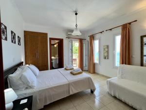 a white bedroom with a bed and a couch at Villa Korfos in Skala