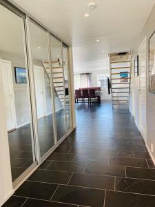 a room with a hallway with glass doors and a tile floor at Grand and modern cabin in Sogndal