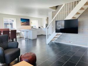 uma sala de estar com uma grande televisão de ecrã plano na parede em Grand and modern cabin em Sogndal