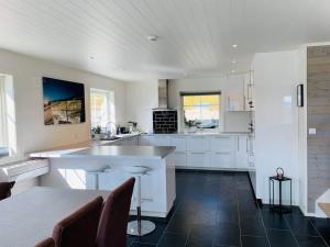 una cocina con armarios blancos y una gran isla en Grand and modern cabin, en Sogndal