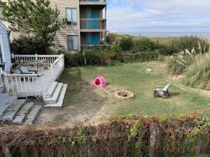 un patio con una hoguera y una casa en Sandy Dunes at the Beach - Beachfront, Wi-Fi, Pets home, en North Camellia Acres