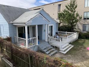 una pequeña casa azul con porche y escaleras en Sandy Dunes at the Beach - Beachfront, Wi-Fi, Pets home, en North Camellia Acres