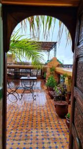an open door to a patio with tables and plants at Dar La Bague de Kenza in Fez