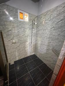 a bathroom with a shower with a stone wall at Zeedijk Resort Nickerie in Nieuw Nickerie