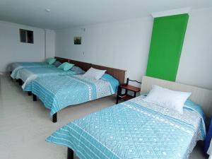 2 łóżka w pokoju zielonym i białym w obiekcie Diamante Blue Hotel w mieście Villavicencio