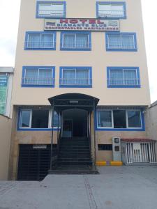 - un bâtiment blanc avec des escaliers menant à une porte dans l'établissement Diamante Blue Hotel, à Villavicencio