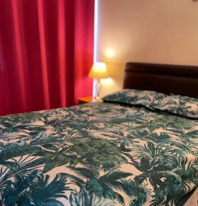 a bedroom with a bed with a green and white comforter at Atlantic Lodge in Newquay