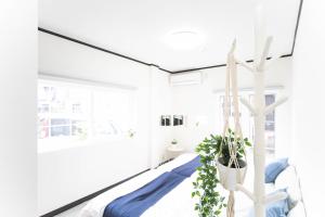 9 min to Yokkaichi Tomida STN House - Vacation STAY 14165 في يوكايتشي: غرفة بيضاء مع سرير وزرع الفخار