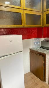 a kitchen with a white refrigerator and red walls at Casa Amanecer Zemzem / Marina Smir in Marina Smir