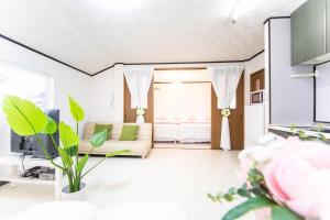 een woonkamer met een bank en een kamer met een bed bij 9 min to Yokkaichi Tomida STN House - Vacation STAY 14165 in Yokkaichi