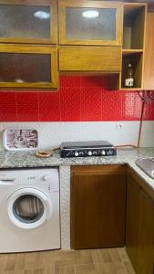 a kitchen with a washing machine and red tiles at Casa Amanecer Zemzem / Marina Smir in Marina Smir