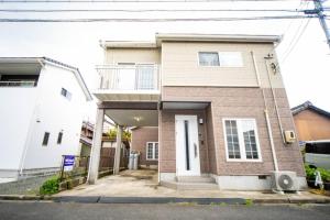 een stenen huis met een balkon in een straat bij 9 min to Yokkaichi Tomida STN House - Vacation STAY 14165 in Yokkaichi